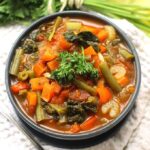 overhead image of healthy vegetable soup in a blue bowl.