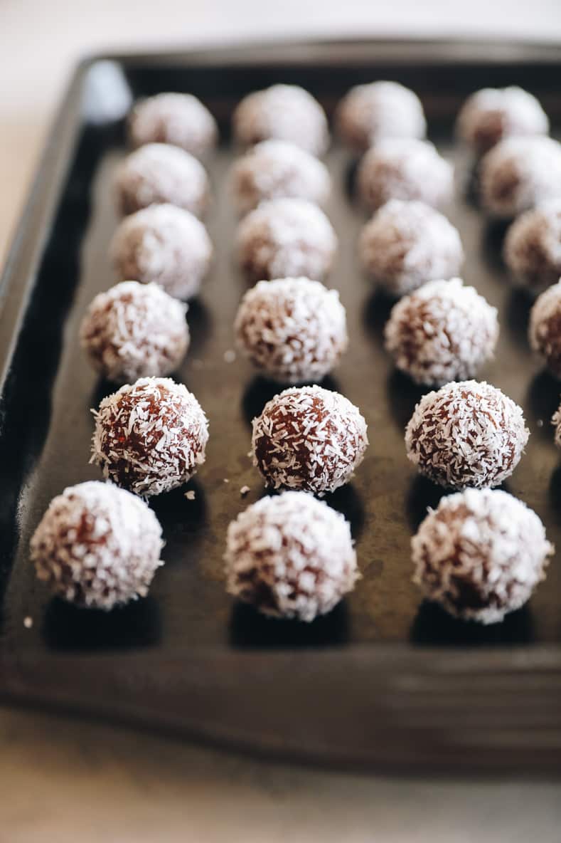 Almond joy energy balls lined on a baking sheet.