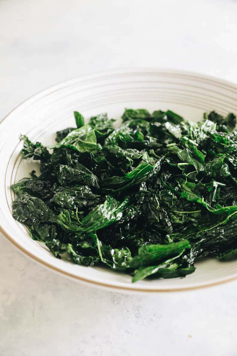 massaged kale in a large white salad bowl.