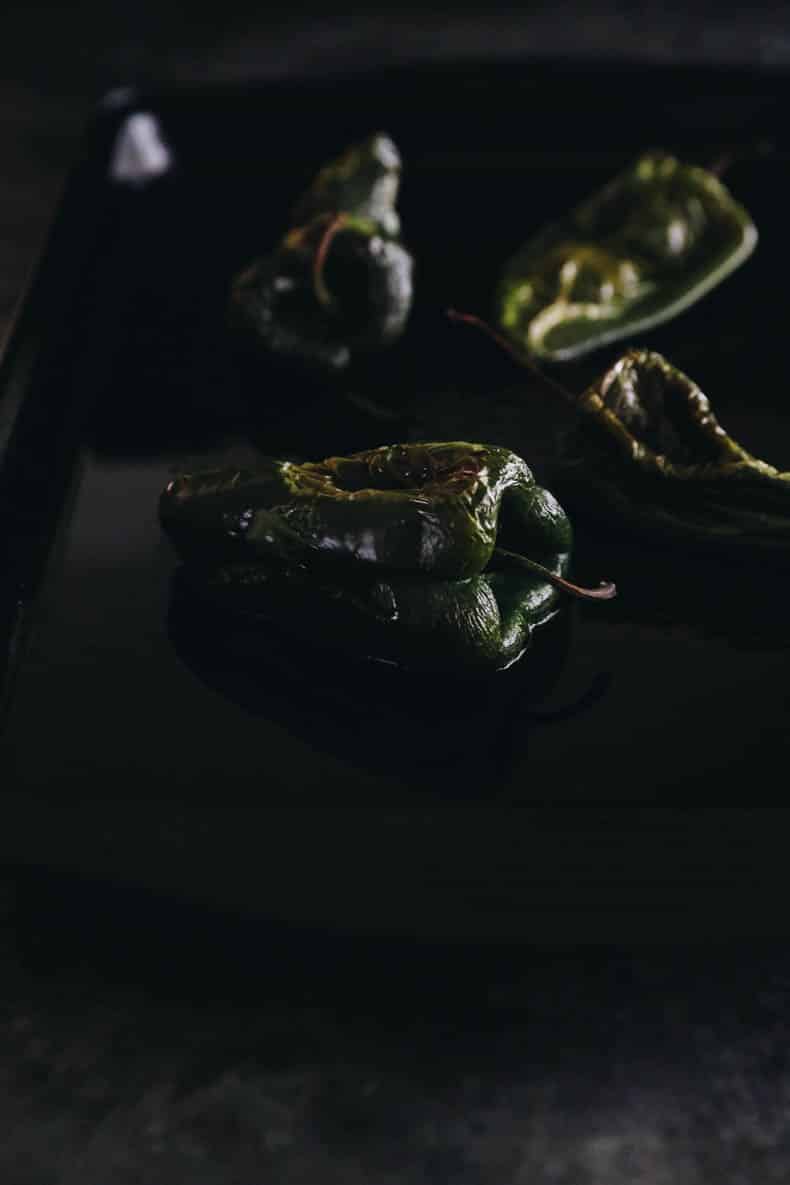 roasted poblano peppers on a baking sheet.