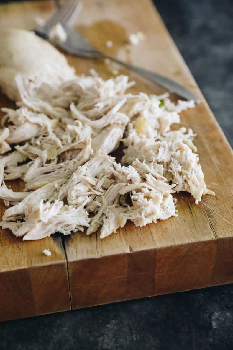 shredded chicken breast on a cutting board.