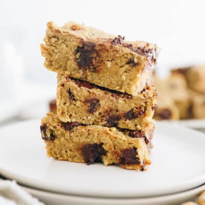 3 chickpea blondies stacked on top of each other on a white plate.