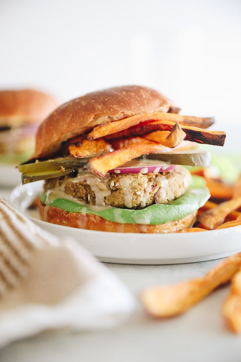 Falafel burger patties on a bun topped with sweet potato fries