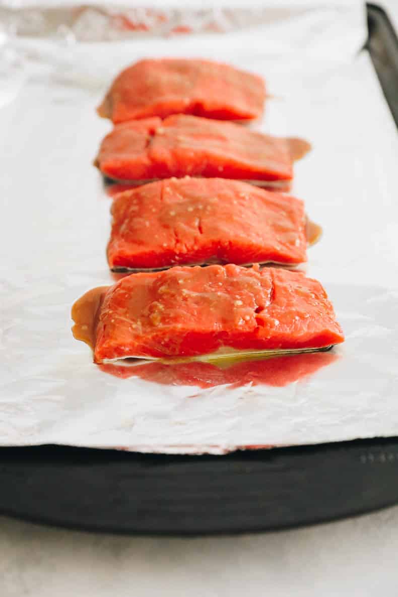 fresh salmon marinated with miso glaze on a baking sheet lined with tinfoil.