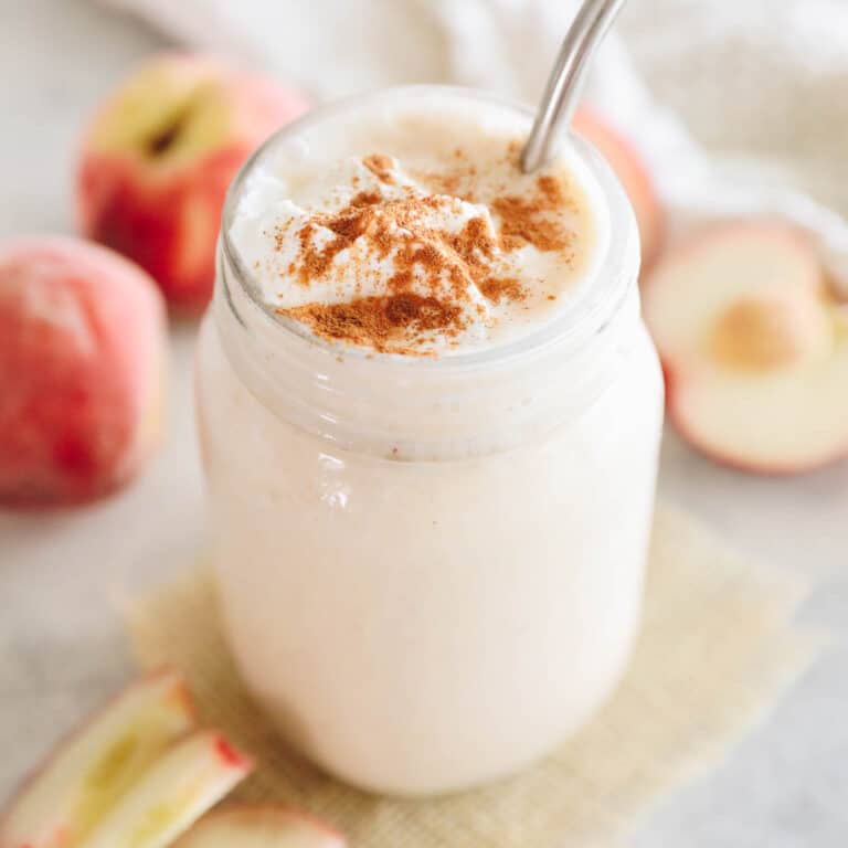 peach smoothie in a mason jar sprinkled with cinnamon.