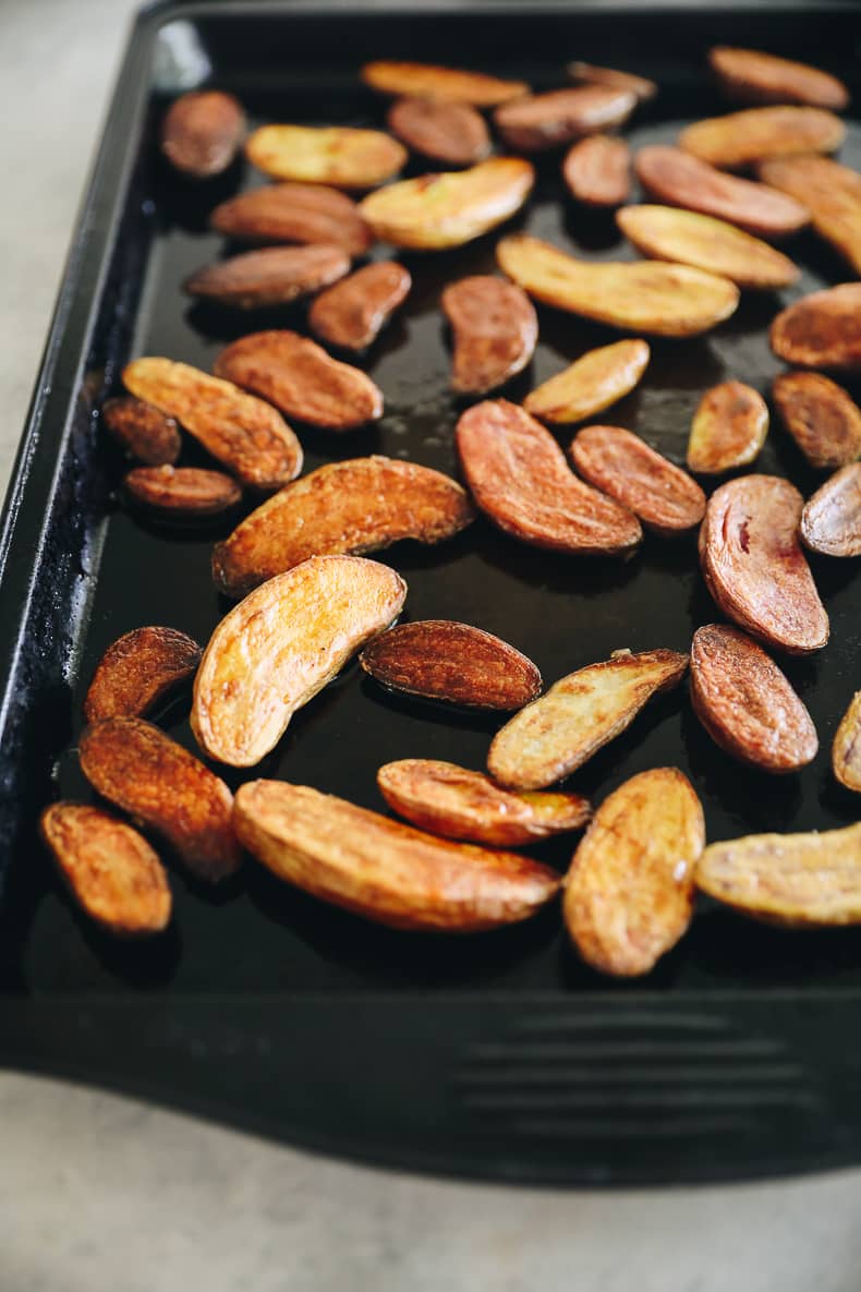 Roasted fingerling potatoes on a baking sheet.