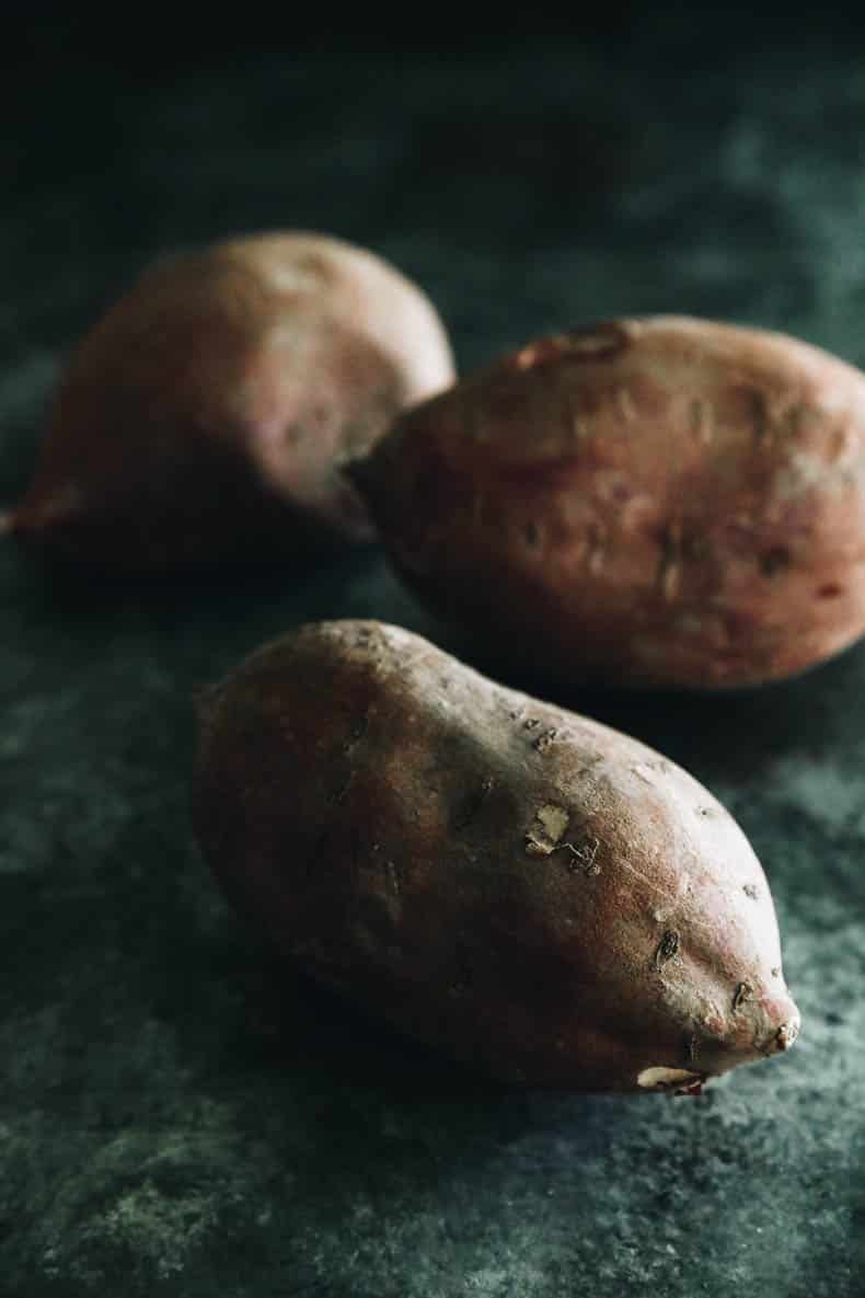 3 Japanese sweet potatoes on a countertop.