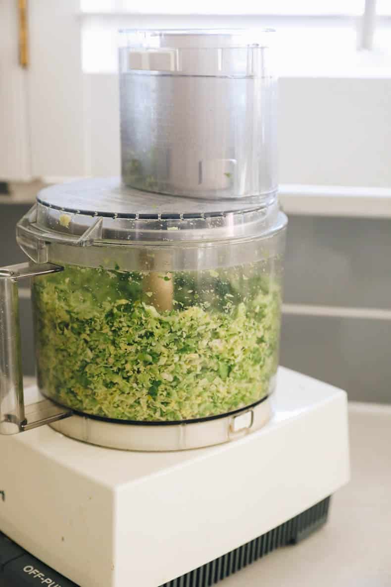 shaved brussel sprouts in a food processor with shaver attachment.