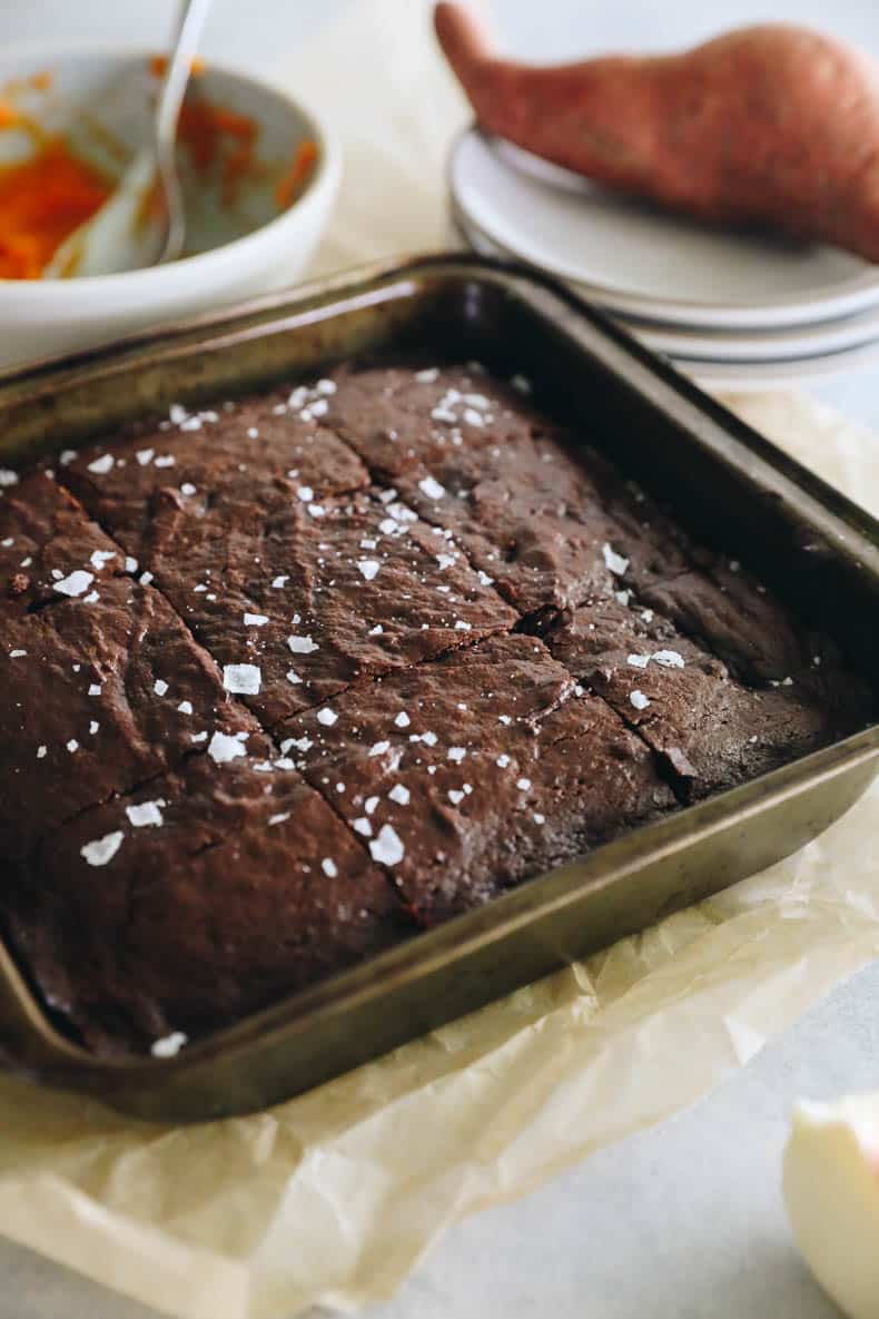 Baked sweet potato brownies cut into 9 squares in a pan.