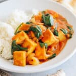 tofu curry in a white bowl with rice.