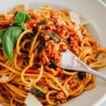 up-close photo of tofu pasta on a fork in a white bowl.